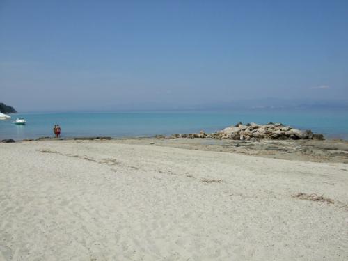 Der Strand von Afitos ist ein Sandstrand. Im flachen Wasser säumen oft Steinplatten die Uferkante.