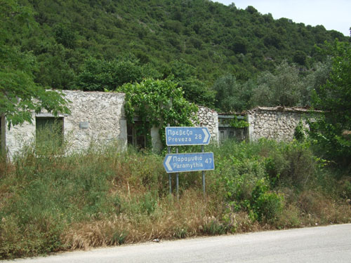 Straßenschild (Preveza - Paramythia) mit Ruinen dahinter