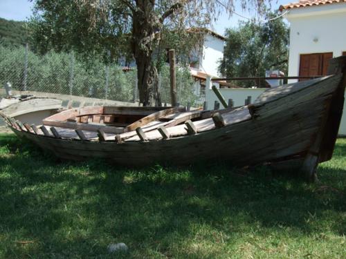 Das Wrack eines alten Fischerbootes in einem Vorgarten.