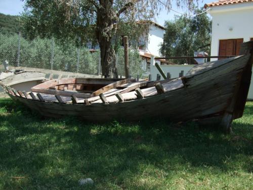 Das Wrack eines alten Fischerbootes in einem Vorgarten.