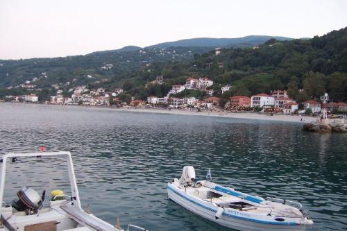 Blick vom Hafen auf Agios Ioannis; Am Berghang in Bildmitte Hotel und Bungalows Kentrikon.